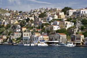 Colorful traditional houses and boats along the waterfront of Symi in the Dodecanese, Greece