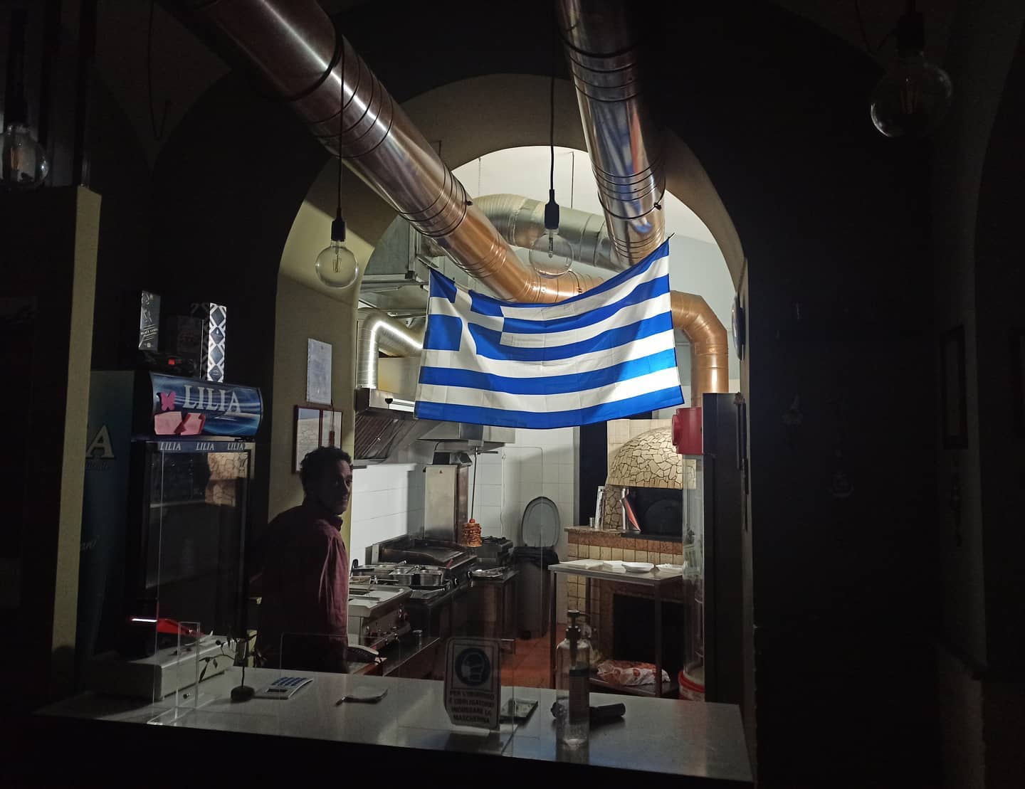 Interior of Giorgos Cucina Greca in Naples with Greek flag display