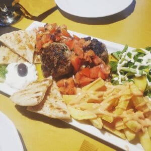 Grilled dish with fries and salad served at Magn' A Grecia in Naples