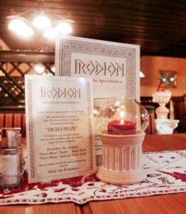 Prepared dining table with Irodion menus and candlelight