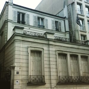 Exterior of the Communauté Hellénique de Paris building with a Greek flag in Paris