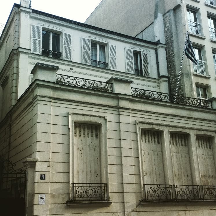 Exterior of the Communauté Hellénique de Paris building with a Greek flag in Paris