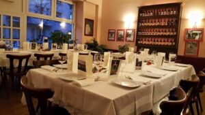 Dining room with prepared tables and wine display at Georgios Restaurant
