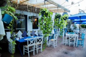 Outdoor dining area with blue and white tables at Meraki Greek Bistro in Miami