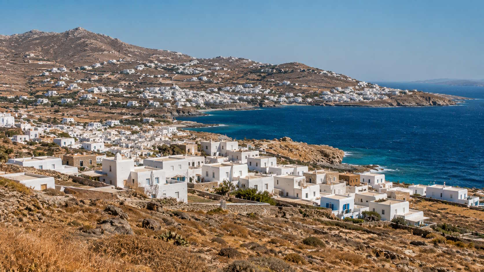 Whitewashed Cycladic settlements and rugged Aegean coastline on Mykonos, Greece