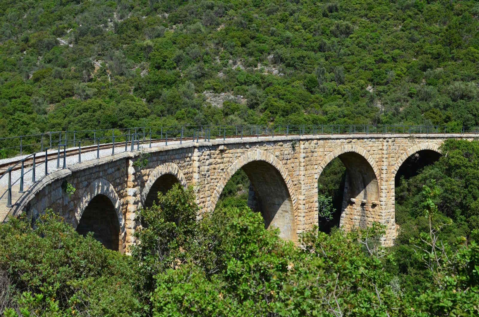 Historic stone railway bridge surrounded by green landscape in Thessaly, Greece