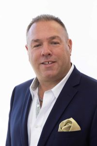 Professional headshot of Tony Economou wearing a dark blazer and white shirt, representing his residential real estate services in Worcester, Massachusetts
