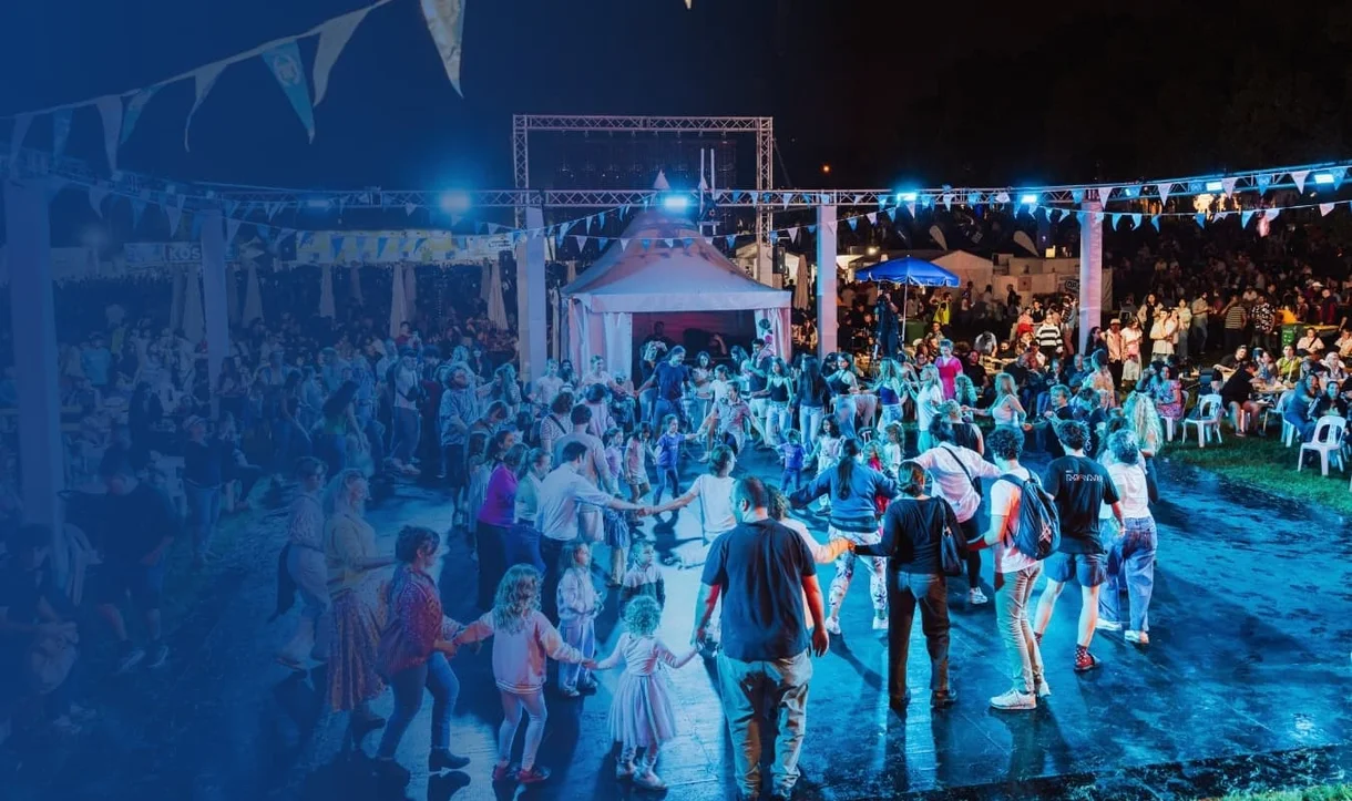 Crowds dancing together at the Gold Coast Greek Festival during an evening cultural celebration